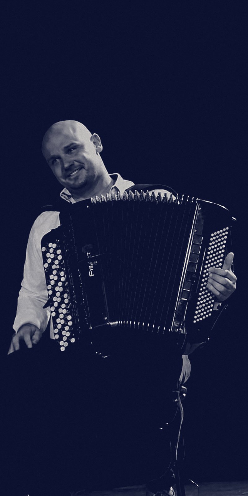 Jérémy Lohier à l'accordéon, sur scène, le regard tourné vers la chanteuse